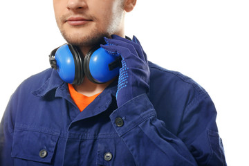 Wall Mural - Male worker with headphones on white background. Hearing protection equipment