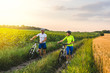 © sergo321 - young man and woman are driving their bicycles on their way to the field in the summer.
