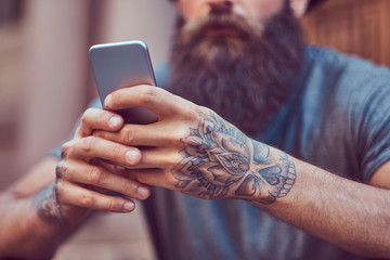 A handsome hipster male with a stylish beard and a tattoo on his