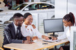 © alfa27 - happy African couple and female seller sit at table and make a deal for sale of car