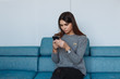 © Andrey - girl with smartphone on the sofa