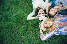 Trendy Hipster Girls Relaxing On The Grass . Summer Lifestyle Portrait Of Three Hipster Women Laying On The Grass Enjoy Nice Day, Wearing Bright Sunglasses. Best Friends Girls Having Fun, Joy.