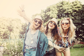 Happy friends in the park on a sunny day . Summer lifestyle portrait of three hipster women  enjoy nice day, wearing bright sunglasses. Best friends girls having fun, joy. Lifestyle