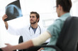 © ASDF - orthopedist examining a radiograph of a patient