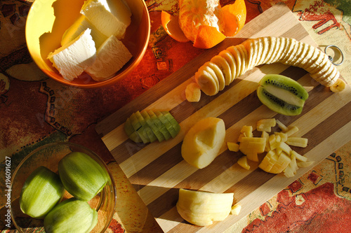 Zdjęcie XXL Śniadanie z owoców. Deser owocowy. Lody, kiwi, mandarynka, jabłko i banan na pokładzie kuchni. Pokrojone owoce. Zdrowa żywność. Przydatne słodycze.