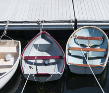 Three Rowboats Tied Up In Line To A Dock In Maine