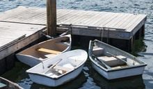 Three Row Boats With Oars Tied To A Dock