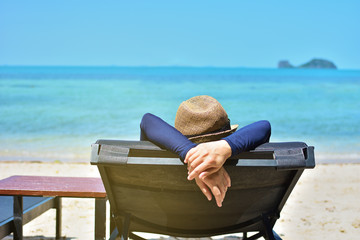 Woman relaxing on a tropical beach with hat