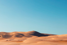 A Vast Desert View With Clear Blue Sky During The Day.