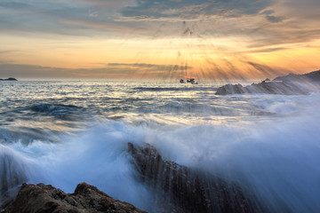 Wall Mural - Splash of wave on seascape at sunset in Phuket, Thailand.