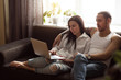 © uv_group - Attractive young couple using a laptop in the living room together