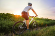 © sergo321 - male cyclist riding a bicycle between fields in summer at sunset
