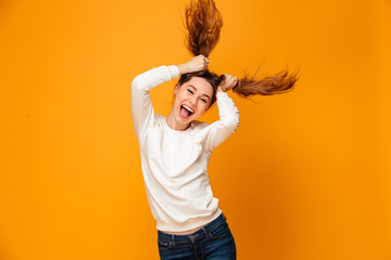 Poster - Laughing brunette woman in sweater holding her hair