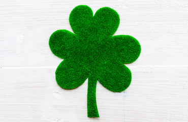 Wall Mural - Happy St Patricks Day message on green paper clover and white wooden background