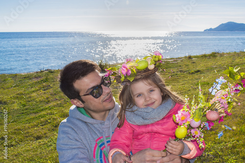 Plakat Wesołych Świąt Wielkanocnych. Ojciec z małą córeczką bawić się nad morzem. Rodzinny czas wiosenny