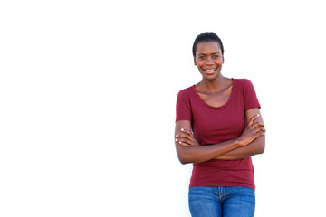 Wall Mural - smiling young black woman standing with arms crossed on white background