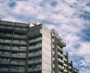 Residential building made in brutalist high-tech architecture style - house is made of grey conrete. Retro filter simulation