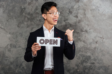 Canvas Print - Portrait of a happy young asian man dressed in suit