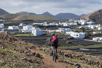 Seniorin unterwegs mit dem Mountainbike auf der Insel Lanzarote, Kanarische Inseln