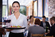 Professional waitress holding serving tray for restaurant guests
