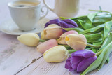 Fototapeta Tulipany - Beautiful bouquet of multicolored tulips and white cup of coffee