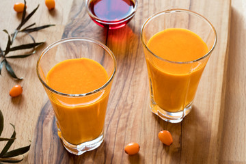 Two glasses of sea buckthorn juice, with sea buckthorn oil and berries