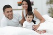 © ASDF - Cheerful family having fun together lying on a bed
