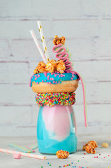 Wall Mural - Freak shake topping with donut, popcorn and marmalade over grey brick background