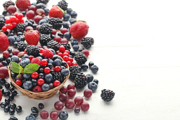 Wall Mural - Ripe and sweet berries in basket on white wooden table