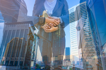 Double exposure photo.  Photo mix  building city and Shake hands. They are join hands  mean teamwork  and spirit beside  building background. Photo concept for business and team work.