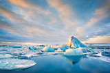 Icebergs float on Jokulsarlon glacier lagoon at sunrise, in Iceland.