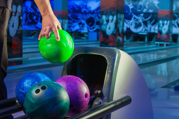 Wall Mural - male hand takes ball for playing bowling