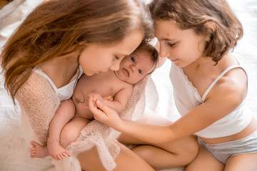 Older sister holding a newborn baby.