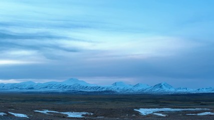 Canvas Print - time lapse of cold steppe in tibet plateau and snow mountain at dusk, Qinghai Hoh Xil nature reserve, China