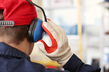 Male worker with hearing protectors, indoors