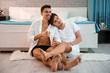 Lovely gay couple spending time together near bed at home