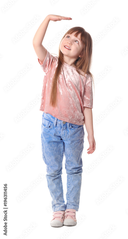 Cute little girl measuring her height on white background