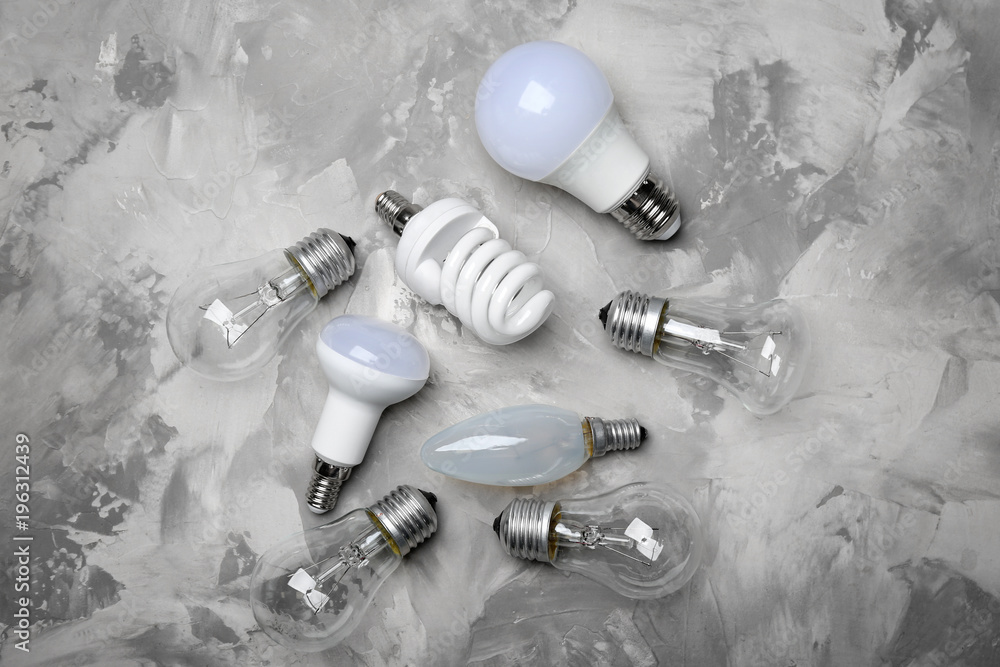 LED, incandescent and fluorescent lamps on grey background