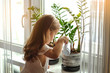 © Olya Komarova - little girl watering and caring for house plants