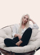 © ASDF - beautiful young woman sitting on the couch in a large comfortable armchair.