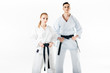 © LIGHTFIELD STUDIOS - karate fighters holding black belts and looking at camera isolated on white