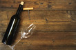 A bottle of wine and a wine glass on a wooden background. view from above.