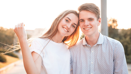 Young man and woman are having fun in the city under sunlight