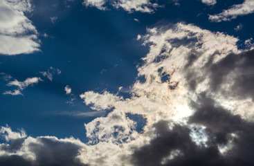 Wall Mural - sun rays against a blue sky in the clouds