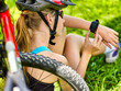 Woman traveling bicycle in summer park. Bicyclist girl watch on smart watch. Girl counts pulse after sport training. Cycling is good for health. School trip.
