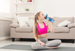 © Prostock-studio - Fitness woman drinking water at home