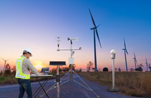 Engineer Using Laptop Computer Collect Data With Meteorological Instrument To Measure The Wind Speed, Temperature And Humidity And Solar Cell System On Wind Turbine Station, Smart Technology Concept