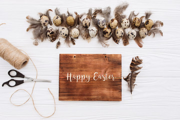 Wall Mural - Text of Happy Easter on a white background with eggs with feathers