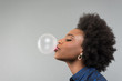 canvas print picture - Young African American Woman blowing bubble with bubble gum