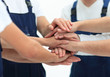 © ASDF - Team of movers showing unity, People putting their hands togethe